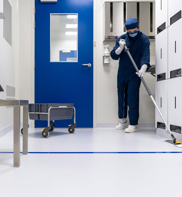 a person in a blue uniform cleaning a room
