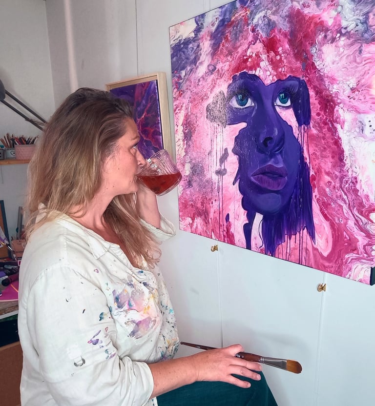 l'artiste peintre Yziya admire une de ses œuvres.