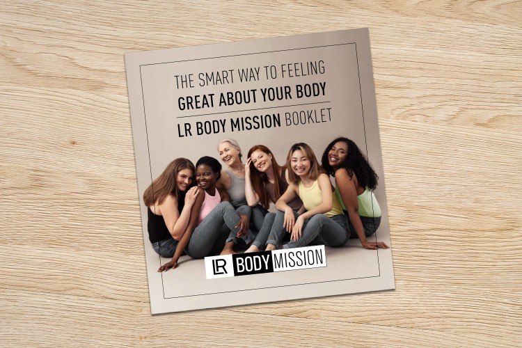 LR Body Mission booklet featuring diverse smiling women on a light wood background for body positivity.