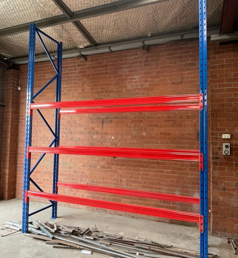 Heavy-duty steel pallet racking with assembled uprights and three sturdy shelves.