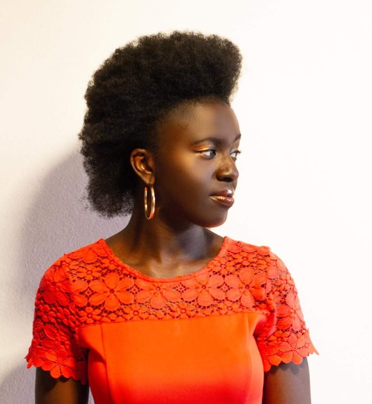 A Black Woman in professional dress with an afro