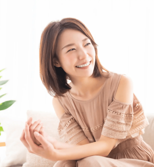 骨盤矯正後に笑顔を見せる日本人女性。安心感と健康を実感するイメージ。