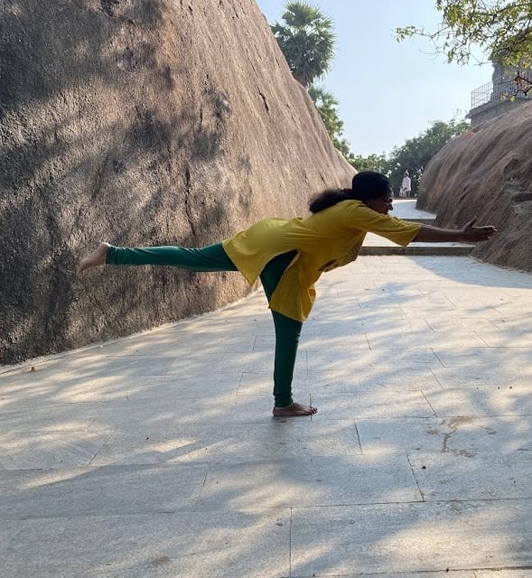 a woman in a yellow shirt is doing yoga