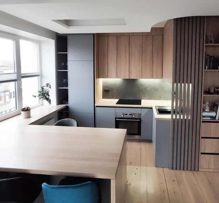 Natural oak ties the custom kitchen and hallway bookshelves together, creating a warm and se