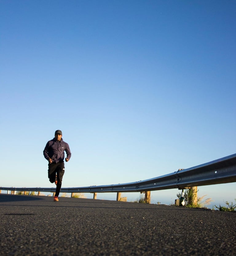 un homme court sur la route près d'une barrière de sécurité