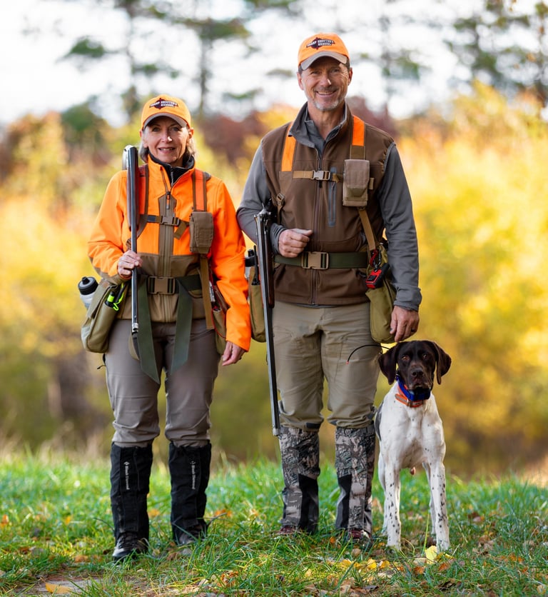 Kennel owners Clyde and Marilyn Vetter in the field with a dog.