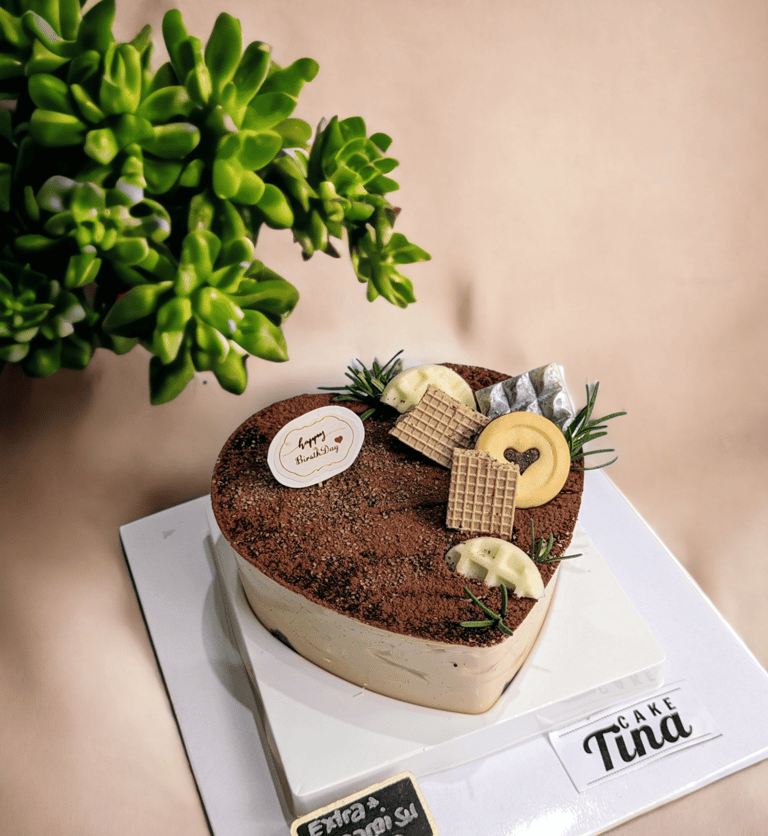 Bánh Tiramisu trái tim với lớp kem mịn vị cà phê, phủ bột cacao nguyên chất. Decor thủ công bằng hoa