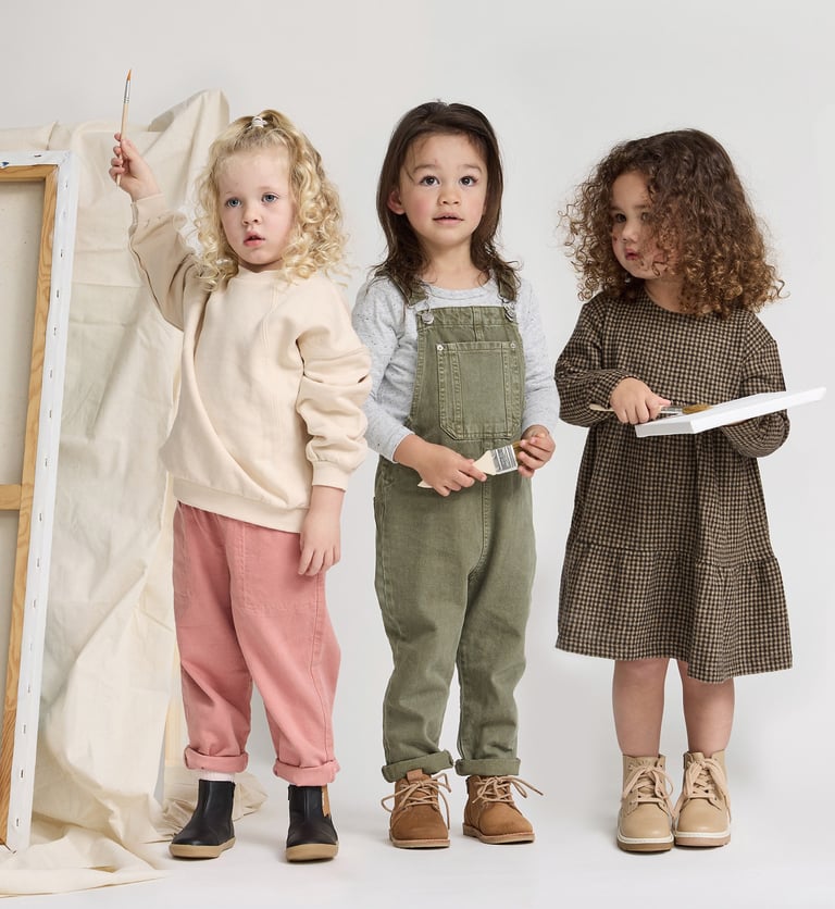 Fashion campaign photography - three young children standing in front of a white canvas