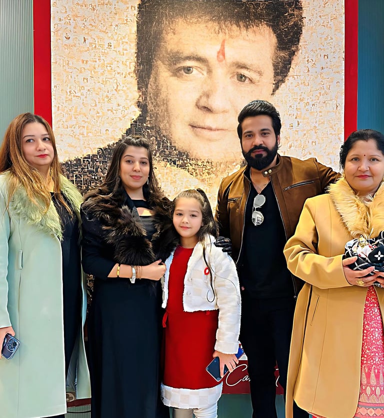 a family posing for a picture in front of a large poster