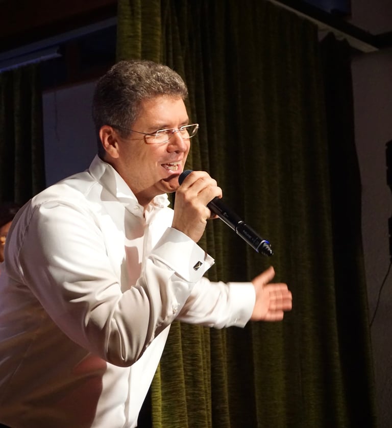ein Mann auf der Bühne, der in ein Mikrofon singt