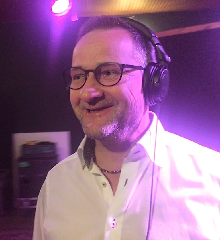ein Mann mit Kopfhörern in einem Tonstudio