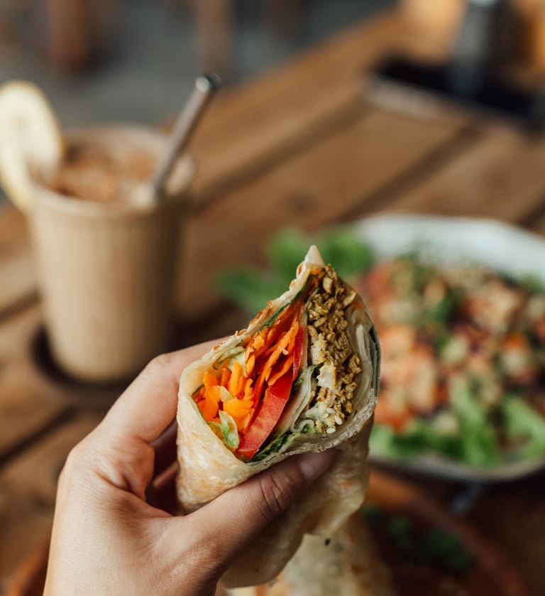 a person holding a sandwich in their hand