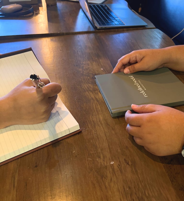 a person holding a book and a notebook