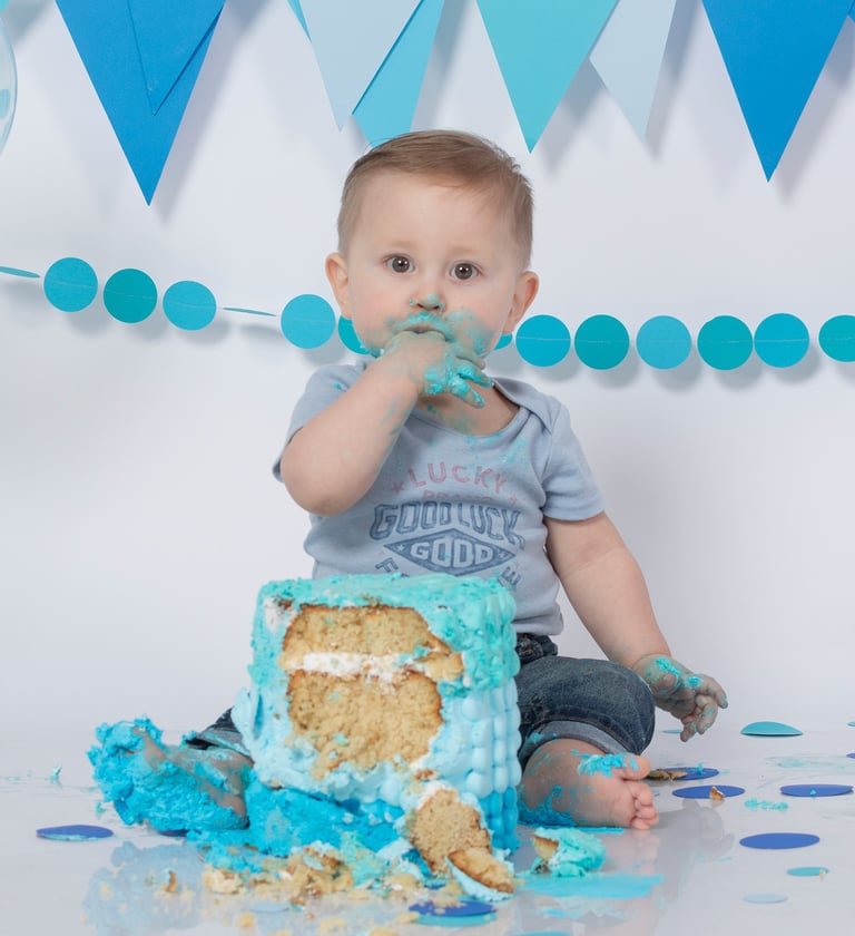 a baby boy in a blue birthday cake