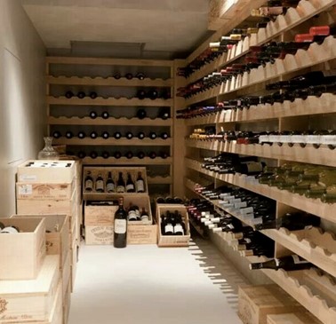 Custom wooden wine cellar storage with wall-mounted racks and crates for organized bottle collection.
