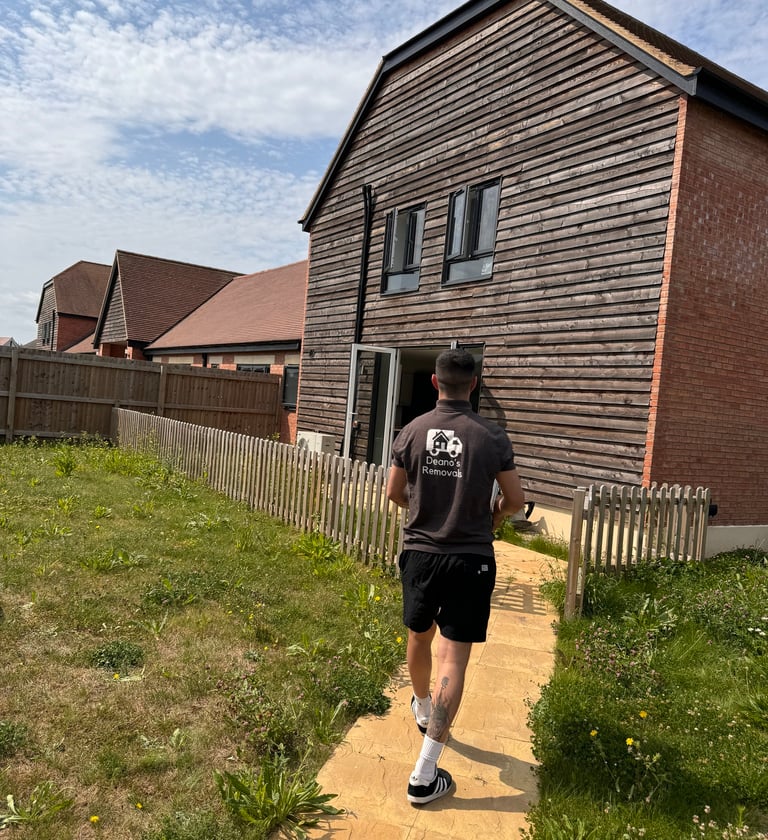 man carrying boxes into a home