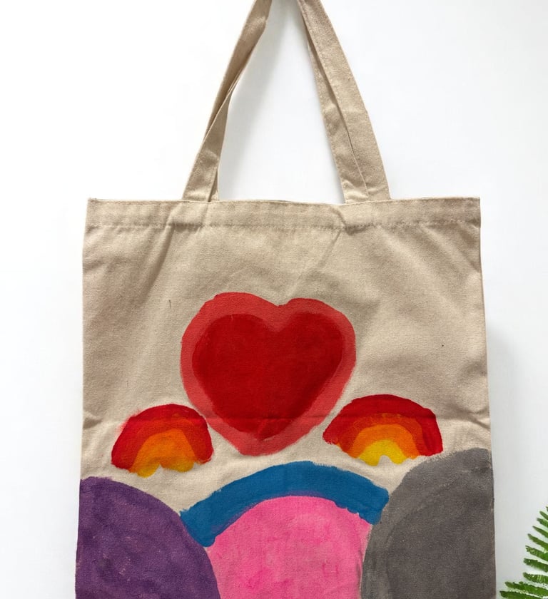 a tote bag with a heart shaped painting on it