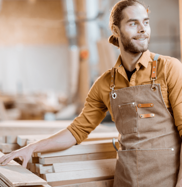 Smiling tradesman at a woodpile