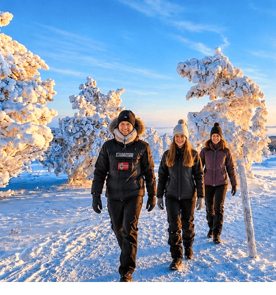 Guests walking among snow-covered trees during a guided tour in Riisitunturi National Park, Finnish Lapland.