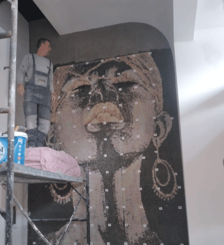 Montage eines maßgeschneiderten Glasmosaiks in einem stilvollen Café-Interieur.