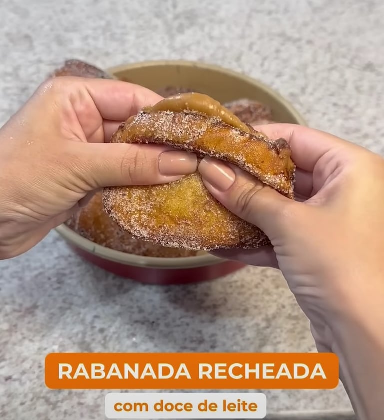 a person holding a doughnut in a bowl, rabanada recheada com doce de leite