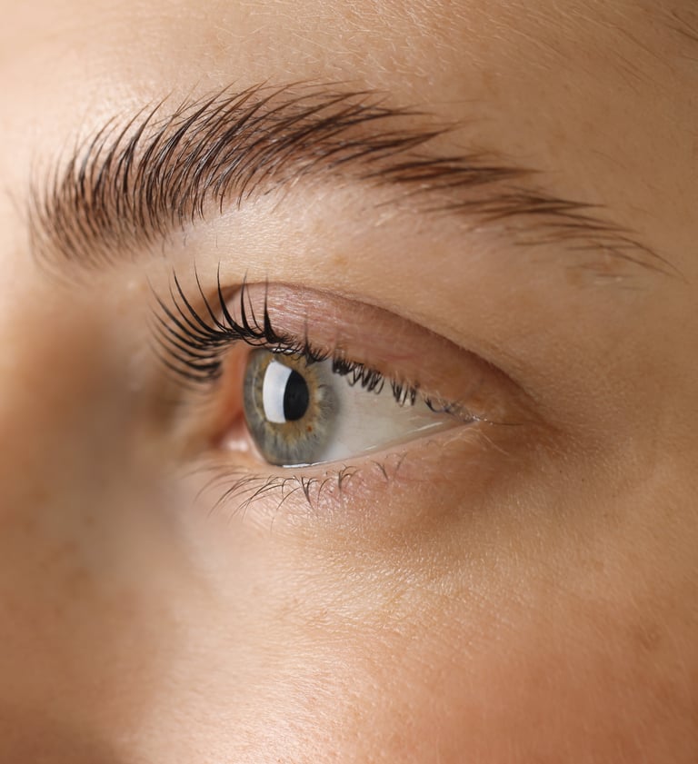 A female client in Oklahoma City showcasing the results of a lash lift and brow lamination, with her