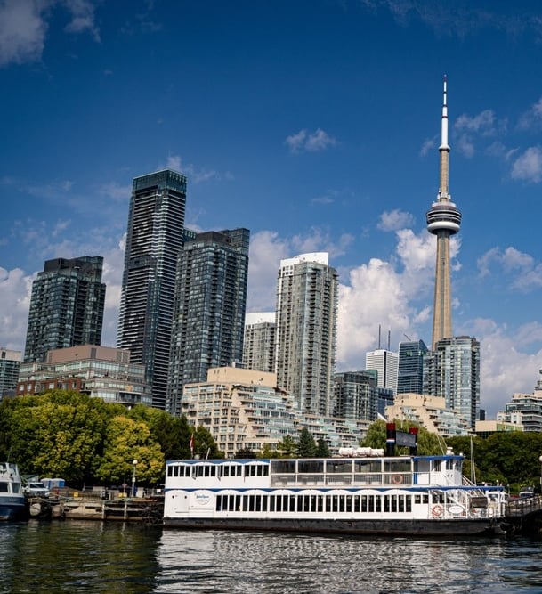a boat on the water with a view of the toronto city