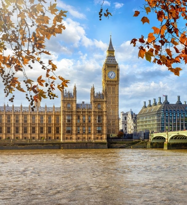 a bridge over a river with a clock tower in the background