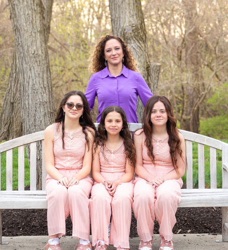 women in a purple shirt with three girls all wearing pink
