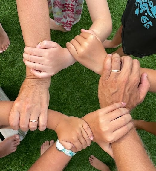 a group of people holding hands together in a circle