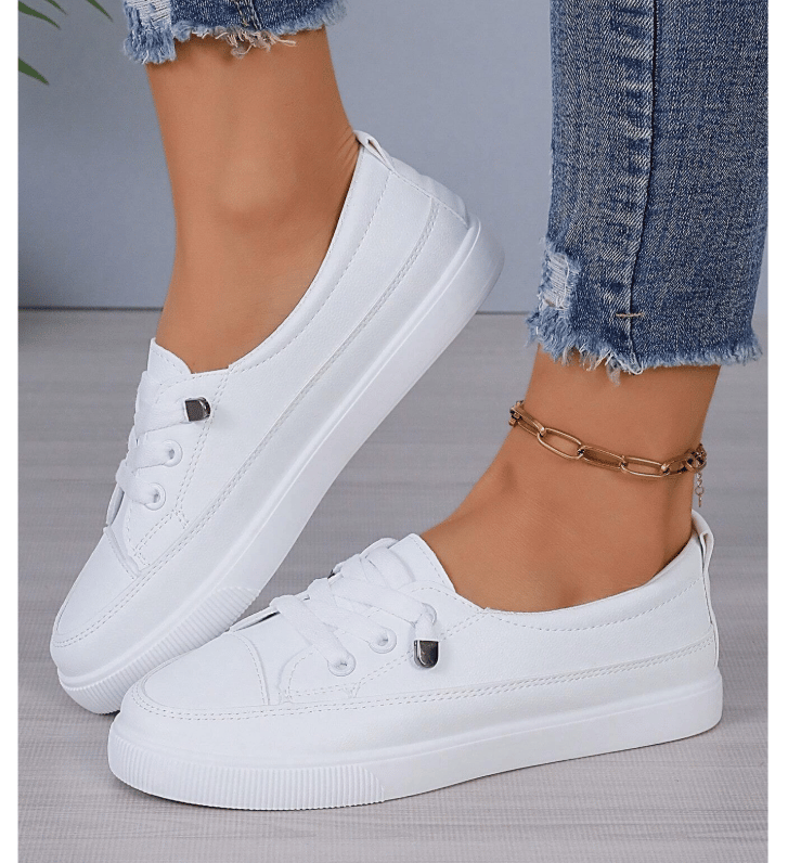 White lace-up fashion sneakers styled with maternity overalls.