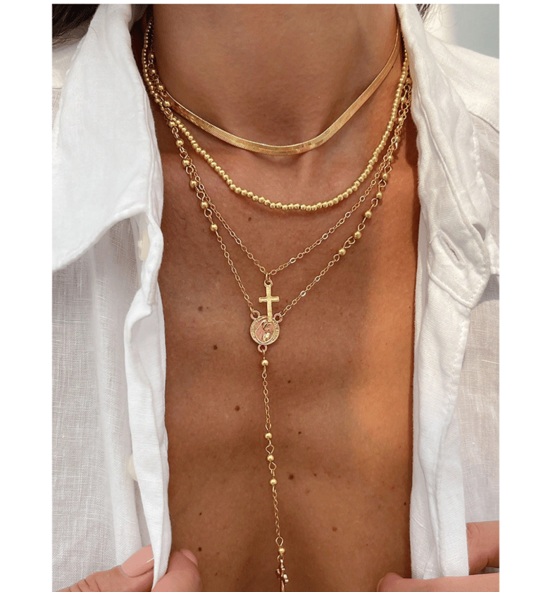 Gold layered necklace set with cross and Virgin Mary pendants.