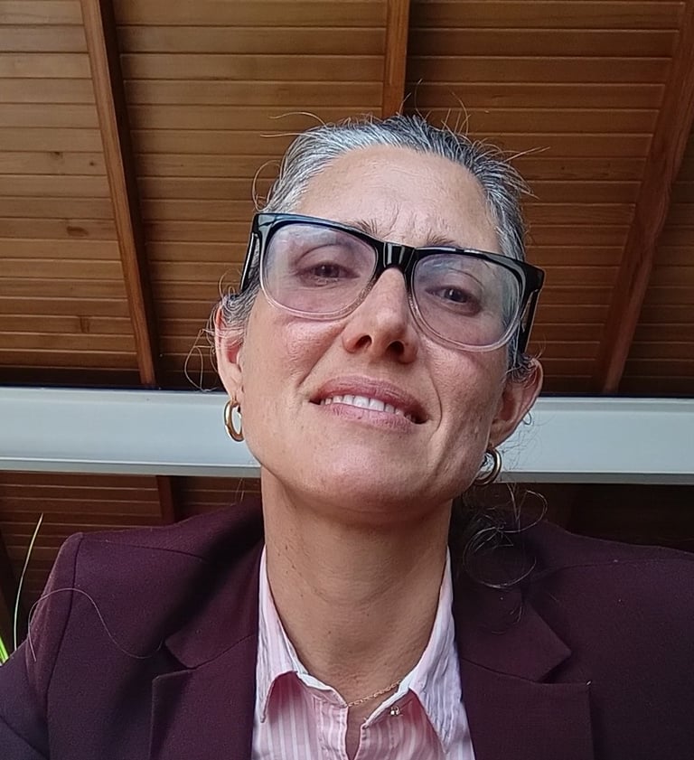 a woman in a suit and glasses sitting on a chair