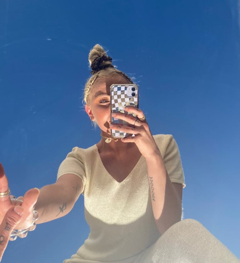 a woman taking a selfie with her phone social media manager