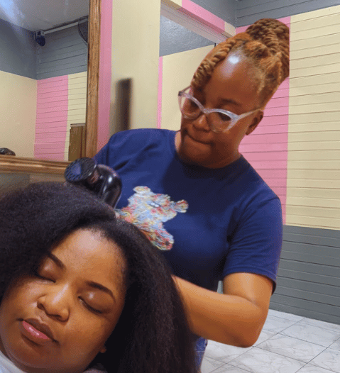 Hairstylist expertly working on a customer's natural hair at Kwik Fingaz Beauty Salon in Montego Bay.