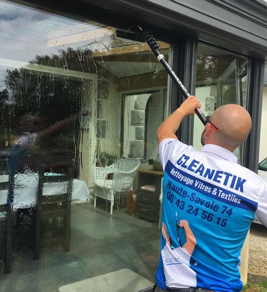 homme qui nettoie une vitre à Annecy