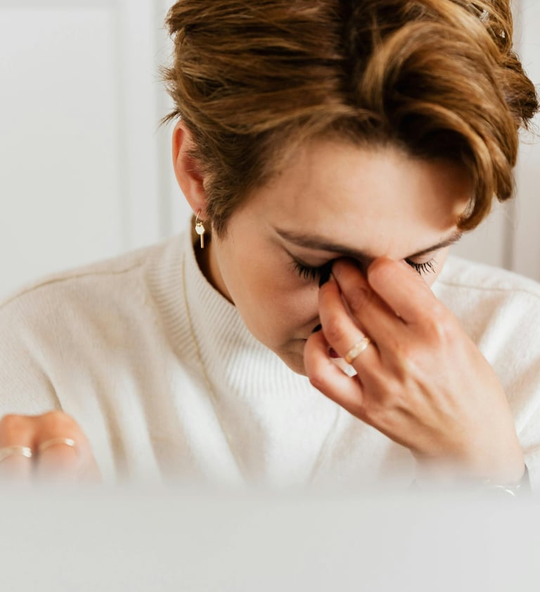 Tired woman rubbing her eyes while suffering from eye strain and headache at work.