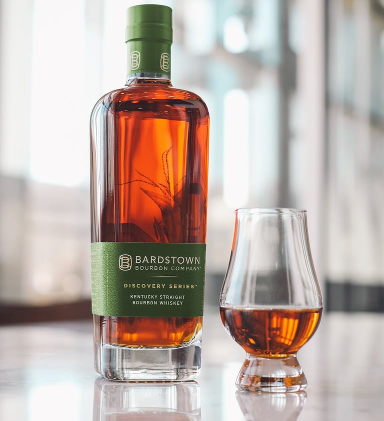 a bottle of bourbon whiskey in front of a glass of whiskey