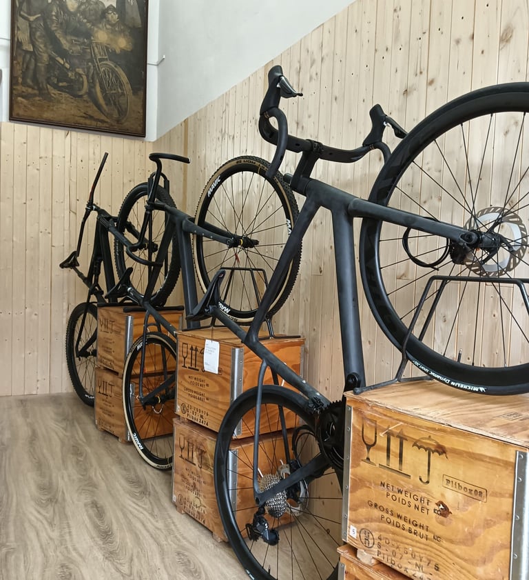 three carbon bikes are parked in a room with wooden crates