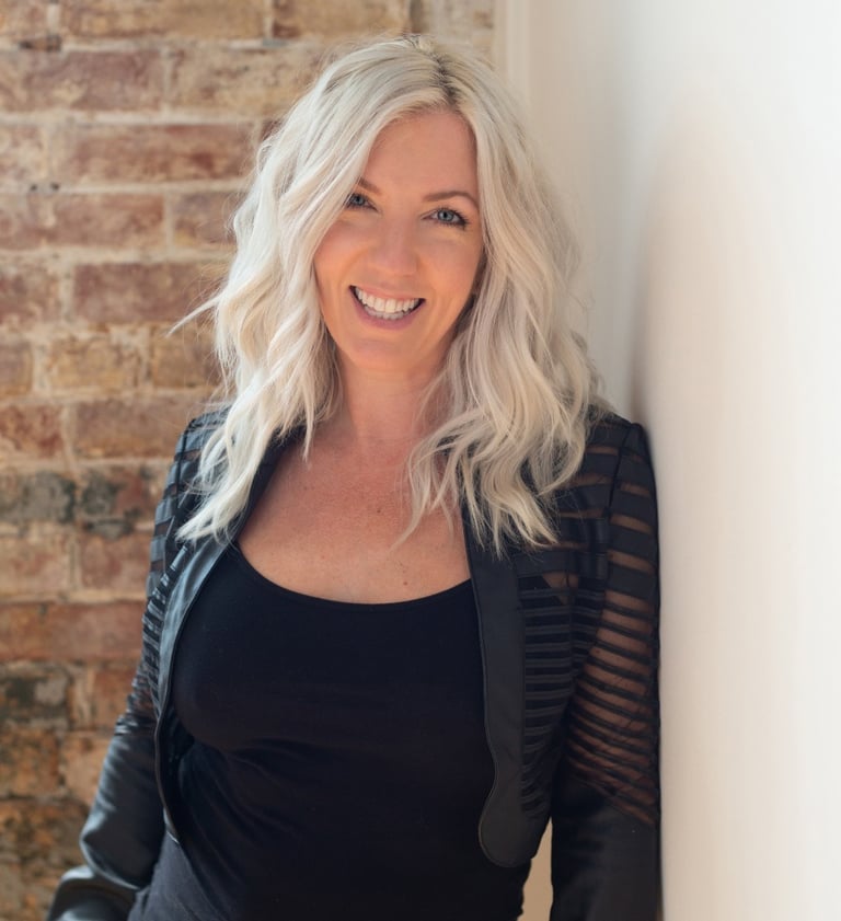 Headshot of artist and photographer Tanya Smith of Sweet Ruby Moon on brick wall