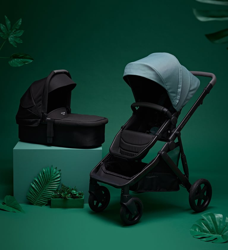 Product campaign photography - a baby stroller and a baby carrier on a green background