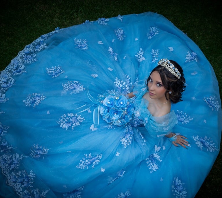 Quinceañera posando para sesión editorial en jardines representativos de Aguascalientes.