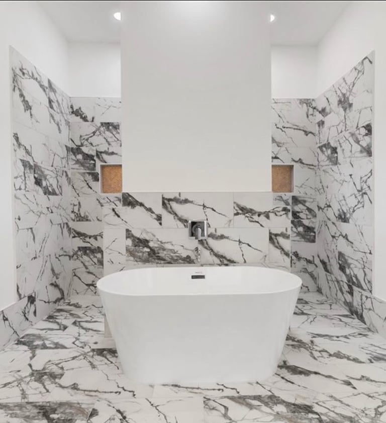 Modern soaking tub with separate vanities in primary bathroom