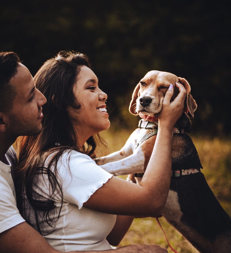 una pareja lfeliz sentada con perrito beagle