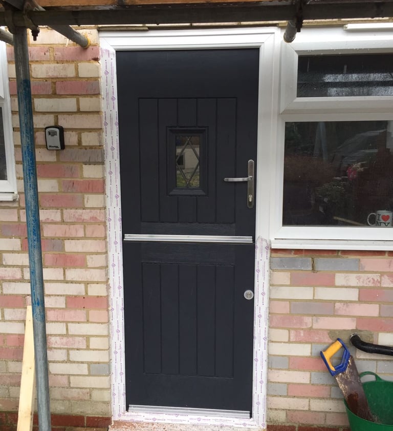 Black stable door with small leaded glass panel