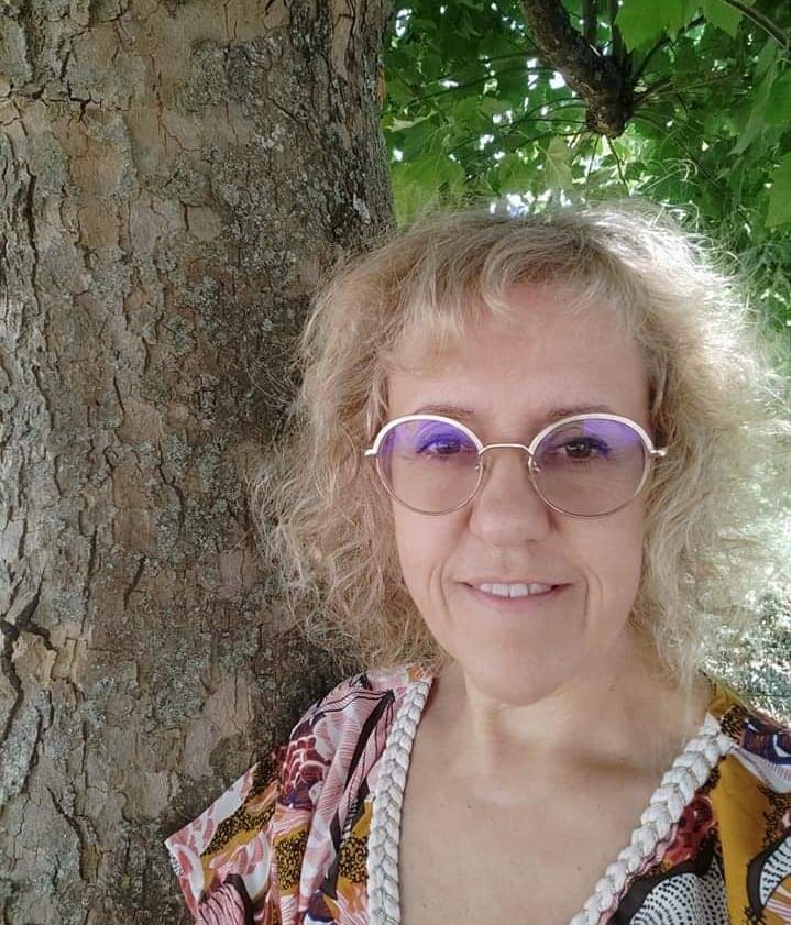 a woman with glasses and a pearl necklace