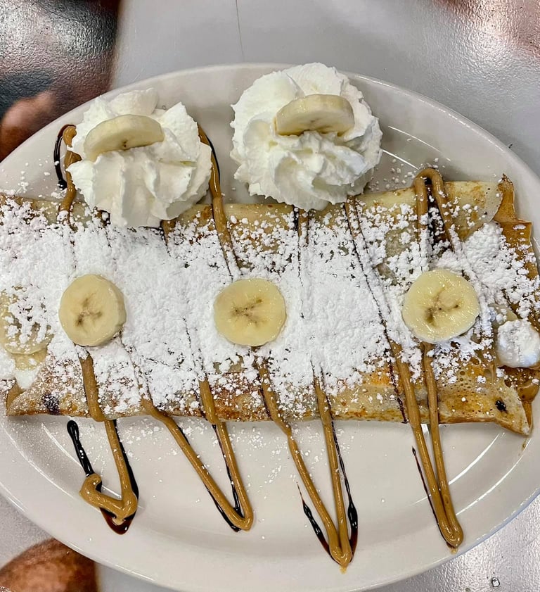 a plate of food with bananas and whipped cream
