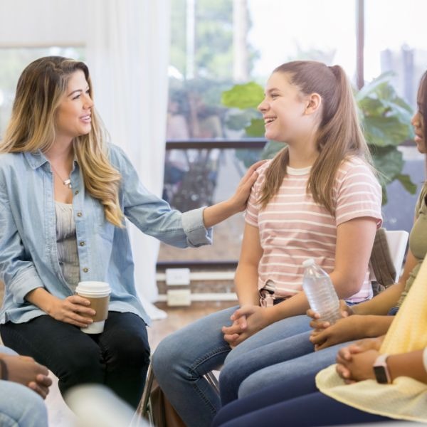 a group of people sitting in a circle with coffee cups