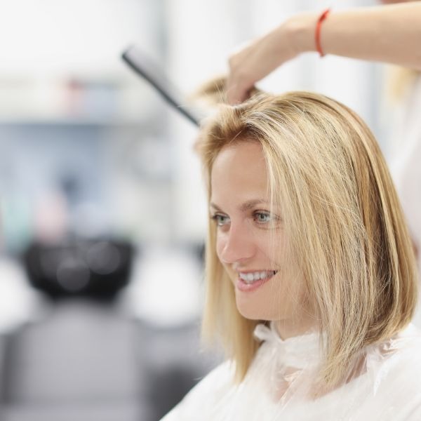 a woman is getting her hair cut by a hairdressuck