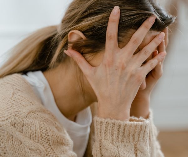 a woman with her hands on her face 